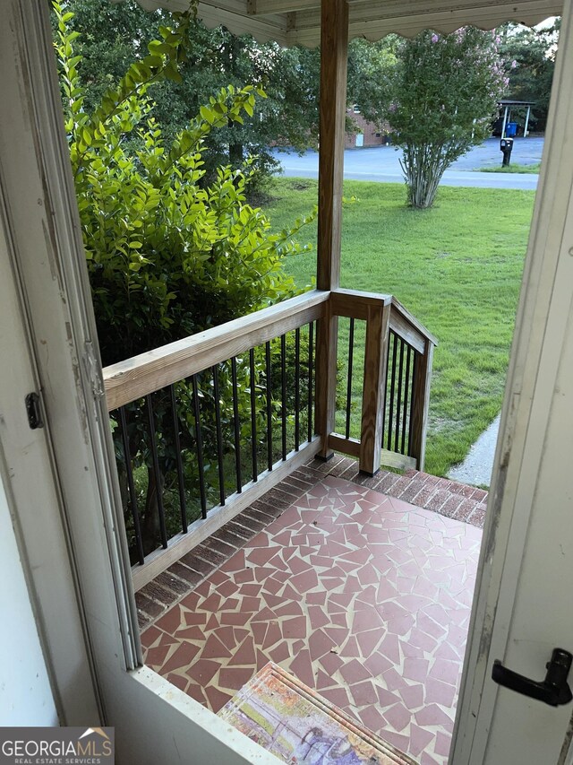 exterior space featuring covered porch and a yard