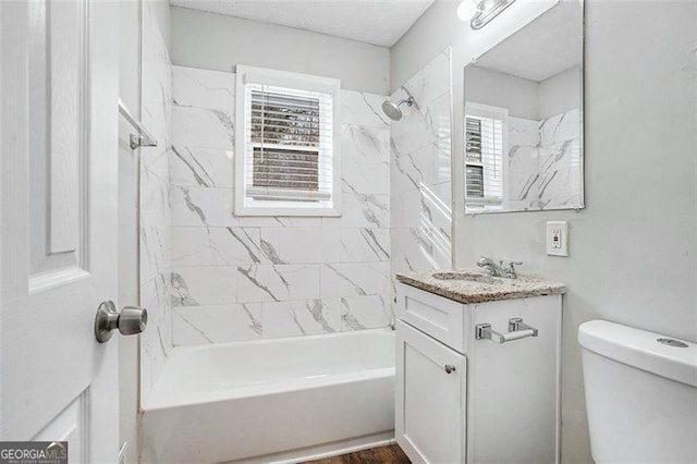 full bathroom with toilet, tiled shower / bath, and vanity