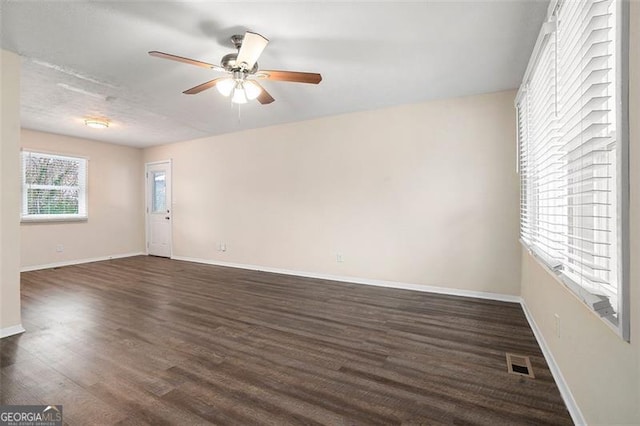 unfurnished room with ceiling fan and dark hardwood / wood-style floors