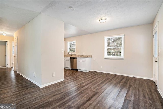 unfurnished living room featuring a textured ceiling, sink, and dark hardwood / wood-style floors