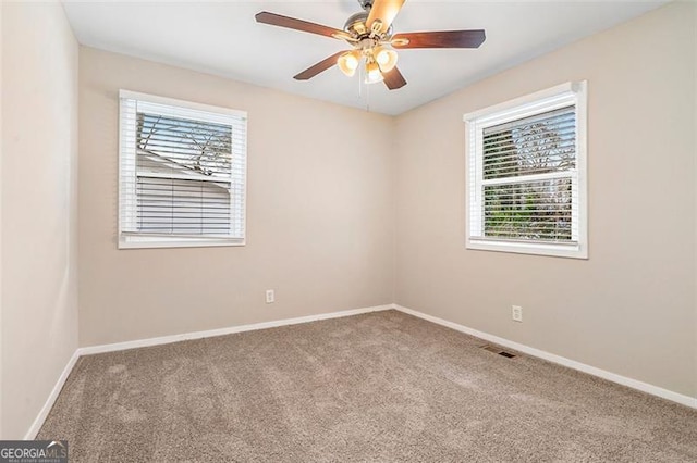 unfurnished room featuring ceiling fan, a wealth of natural light, and carpet flooring