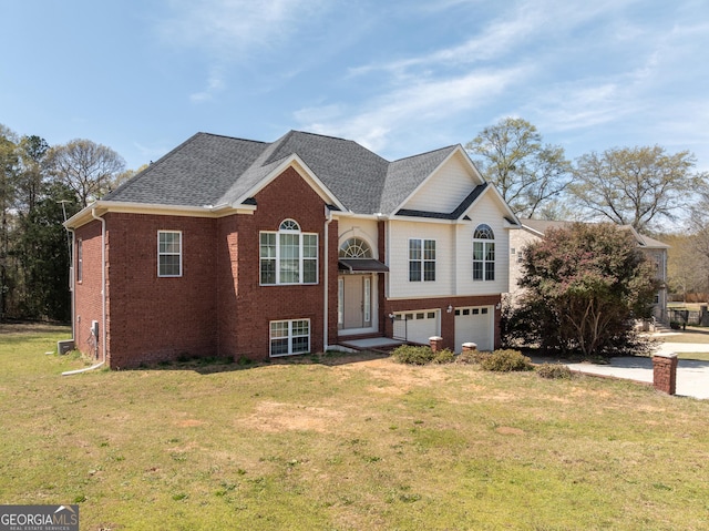 bi-level home with a front yard, a garage, brick siding, and roof with shingles