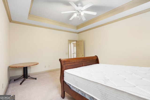 bedroom featuring light carpet, baseboards, crown molding, and a raised ceiling