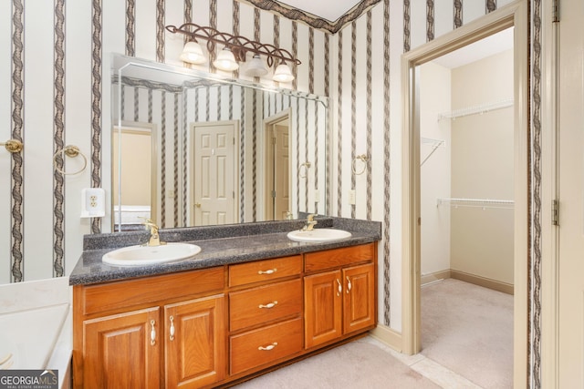 full bath with double vanity, wallpapered walls, and a sink