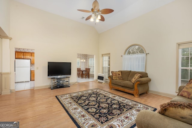 living room with high vaulted ceiling, ceiling fan, and light wood-type flooring