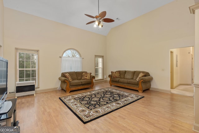 living room with heating unit, high vaulted ceiling, ceiling fan, and a healthy amount of sunlight