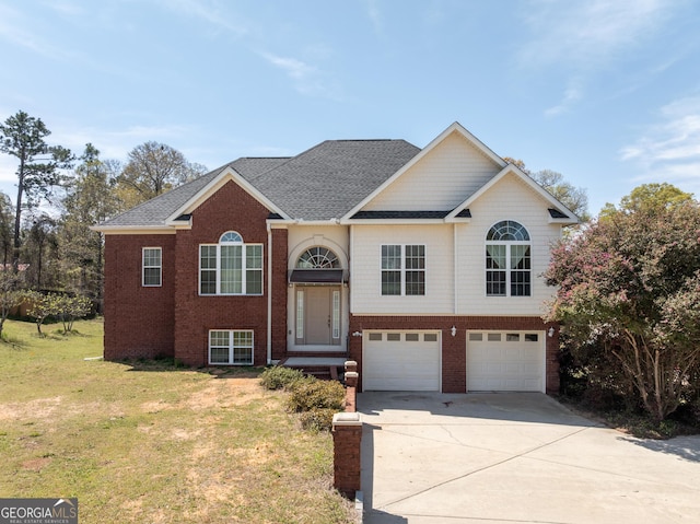 split foyer home with a front yard, concrete driveway, an attached garage, brick siding, and a shingled roof