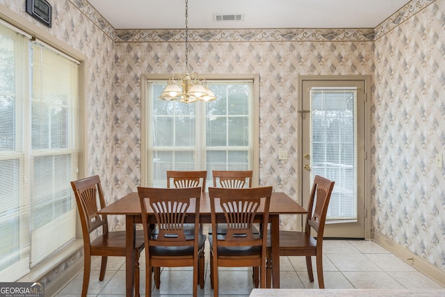 dining space with light tile patterned flooring, visible vents, a chandelier, baseboards, and wallpapered walls