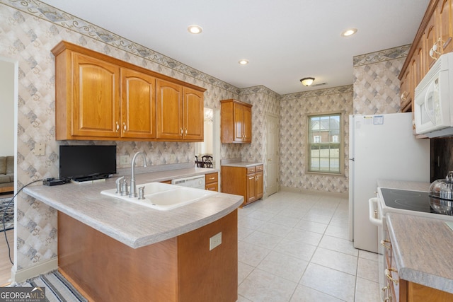 kitchen with a peninsula, white appliances, baseboards, wallpapered walls, and a sink