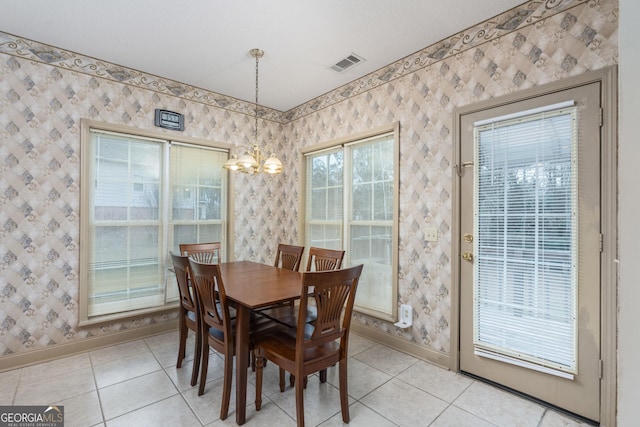 dining room featuring wallpapered walls, light tile patterned floors, a chandelier, and visible vents