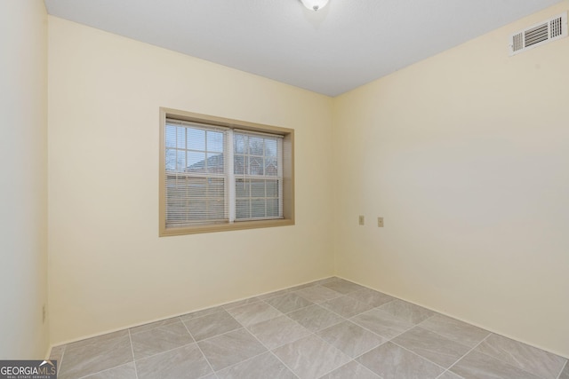 empty room with visible vents and light tile patterned floors