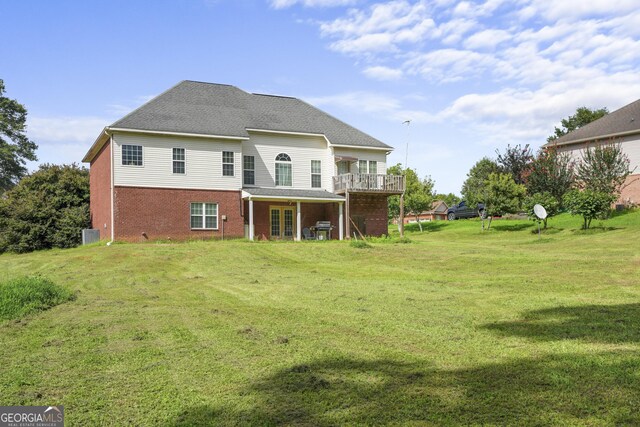 back of property with central AC unit, a deck, and a lawn