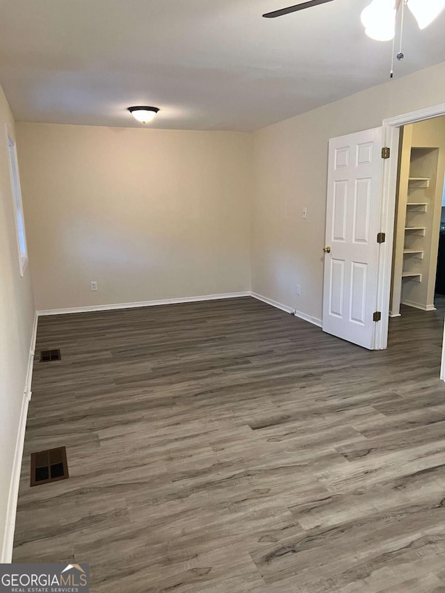 empty room featuring ceiling fan and dark hardwood / wood-style floors