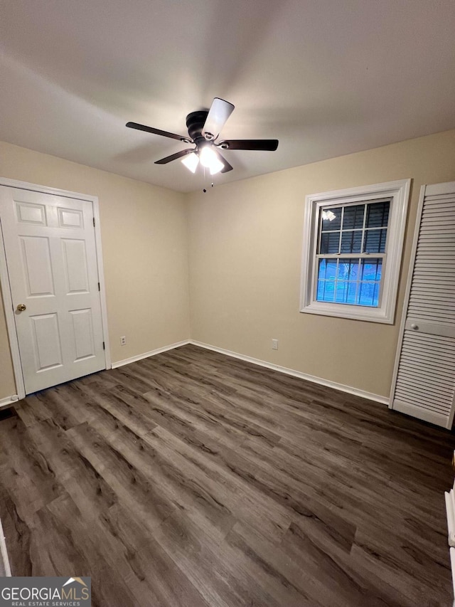 unfurnished bedroom with ceiling fan, a closet, and dark hardwood / wood-style floors