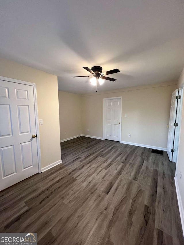 unfurnished room with dark wood-type flooring and ceiling fan