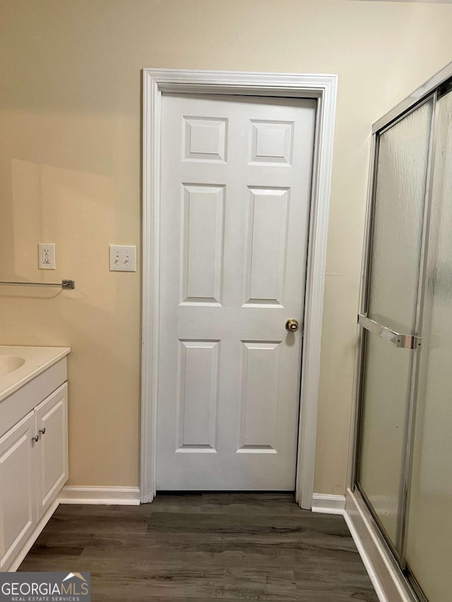 bathroom with walk in shower, wood-type flooring, and vanity