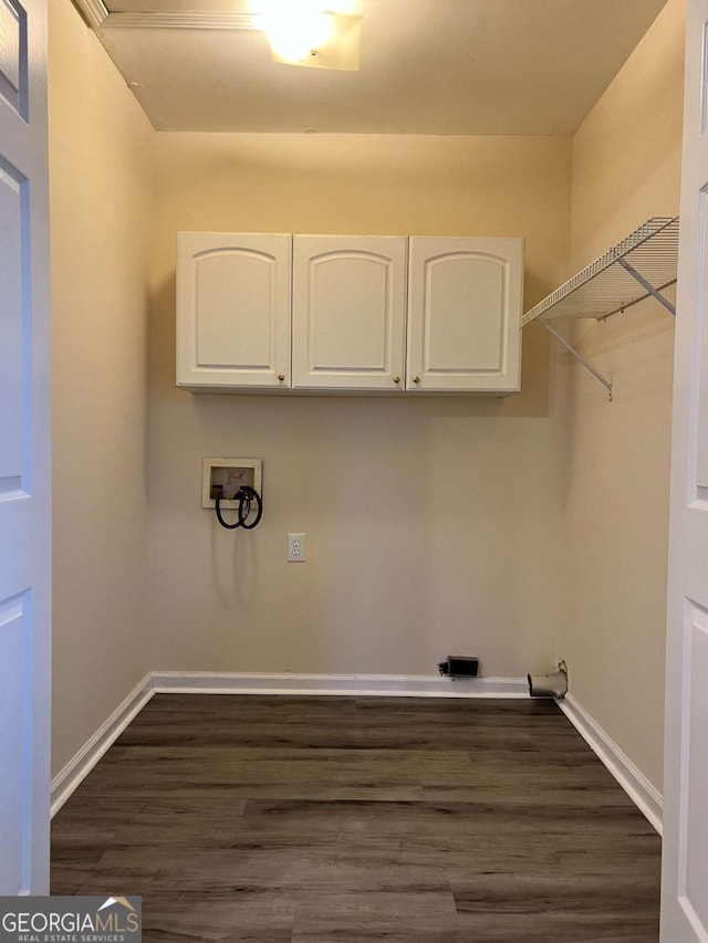 clothes washing area featuring cabinets, hookup for a washing machine, and dark hardwood / wood-style floors