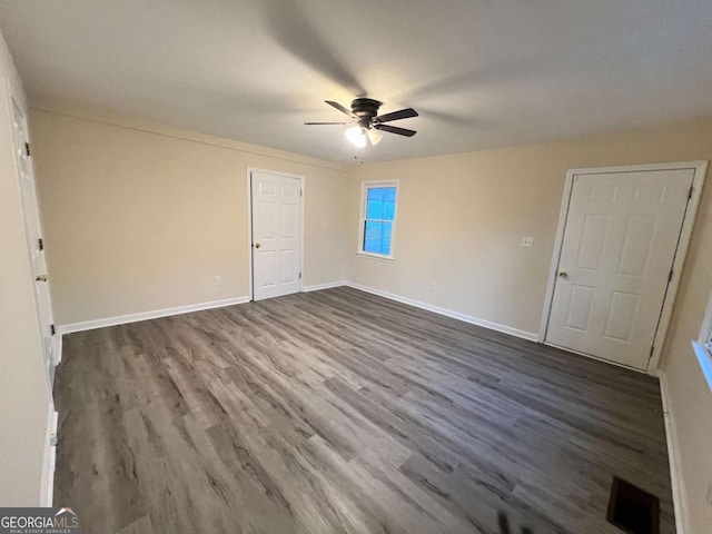 unfurnished bedroom with ceiling fan and dark hardwood / wood-style floors