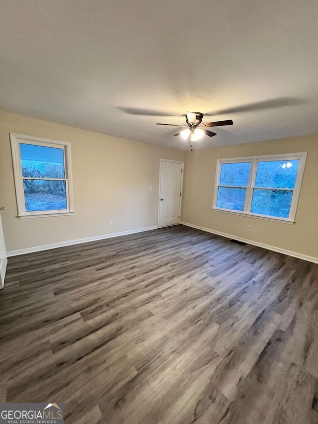 spare room with ceiling fan and dark wood-type flooring