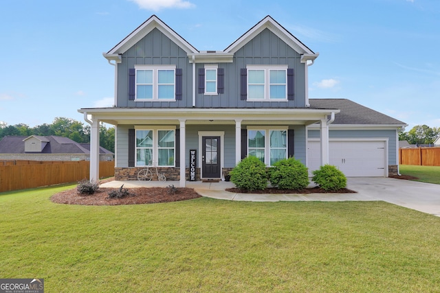 view of front of property with a porch, a front yard, and a garage