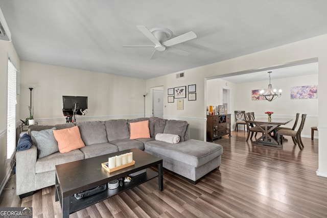 living room with ceiling fan with notable chandelier and hardwood / wood-style flooring