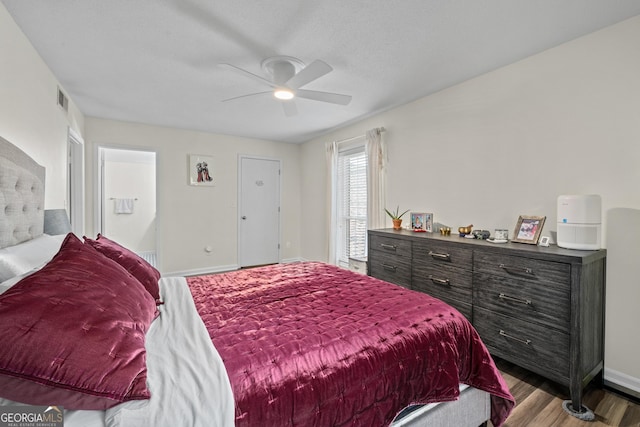 bedroom with a textured ceiling, ceiling fan, and hardwood / wood-style flooring