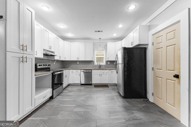 kitchen with decorative light fixtures, stainless steel appliances, backsplash, white cabinetry, and sink