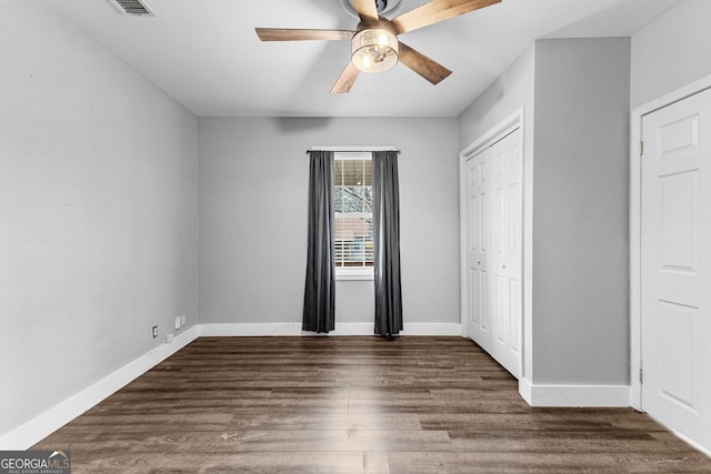 unfurnished bedroom with a closet, ceiling fan, and dark hardwood / wood-style floors