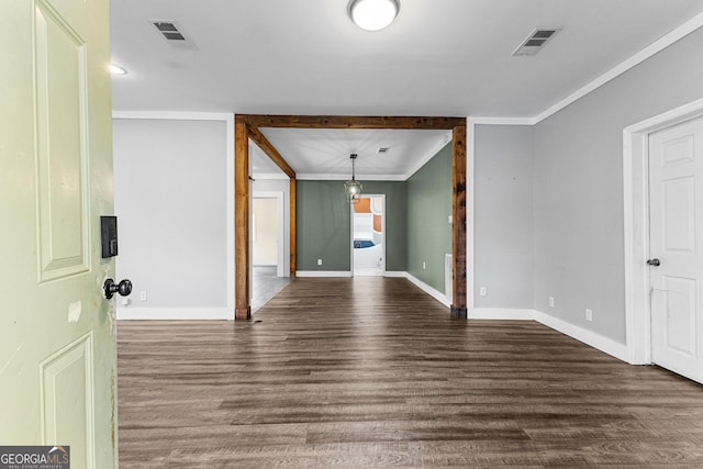 spare room with ornamental molding and dark wood-type flooring