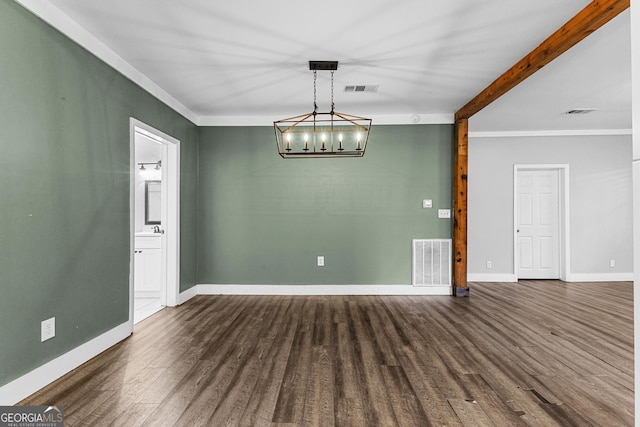 empty room featuring an inviting chandelier, ornamental molding, and dark hardwood / wood-style floors