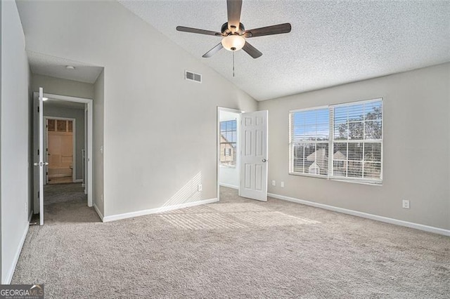 unfurnished bedroom with ceiling fan, high vaulted ceiling, light carpet, and a textured ceiling