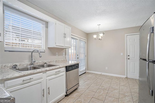 kitchen with decorative light fixtures, a notable chandelier, white cabinets, appliances with stainless steel finishes, and sink