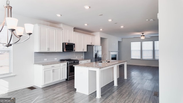 kitchen featuring an island with sink, appliances with stainless steel finishes, white cabinets, and sink