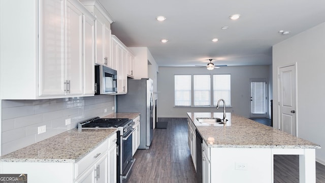 kitchen featuring appliances with stainless steel finishes, an island with sink, white cabinetry, and sink