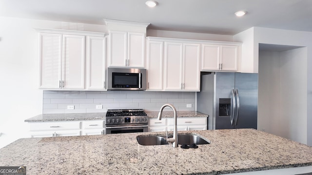 kitchen featuring sink, stainless steel appliances, white cabinets, and decorative backsplash