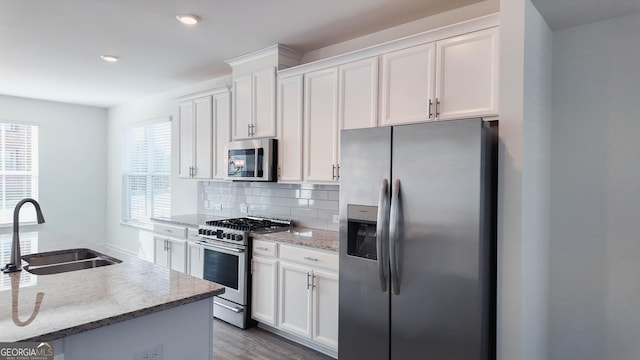 kitchen featuring appliances with stainless steel finishes, white cabinetry, and sink