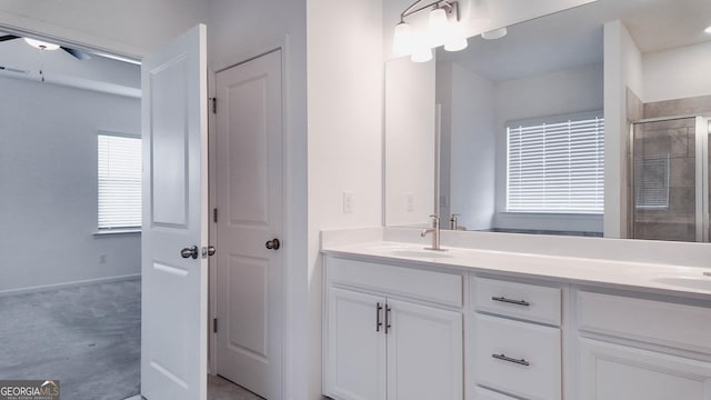 bathroom featuring ceiling fan, a shower with shower door, and vanity