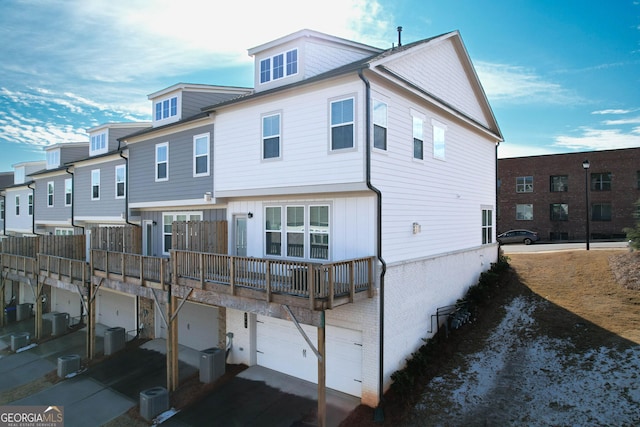 back of property featuring central AC and a garage