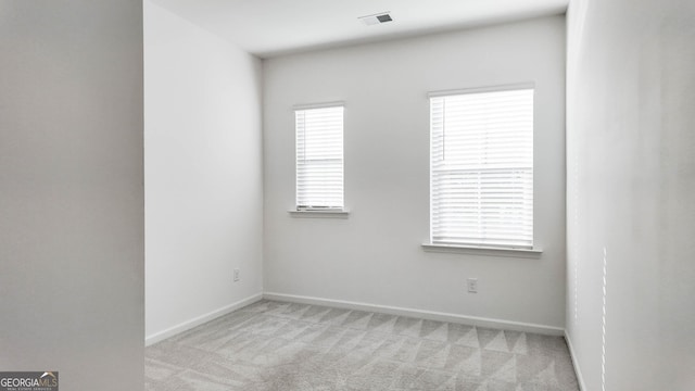 spare room featuring light colored carpet