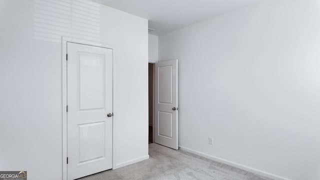 unfurnished bedroom featuring light carpet