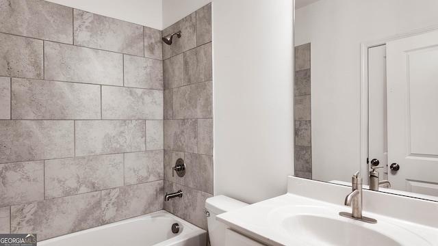 full bathroom featuring vanity, tiled shower / bath combo, and toilet