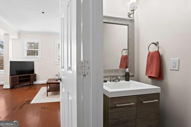 bathroom with ornamental molding, hardwood / wood-style floors, and vanity