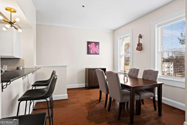 dining space featuring dark wood-type flooring and a chandelier