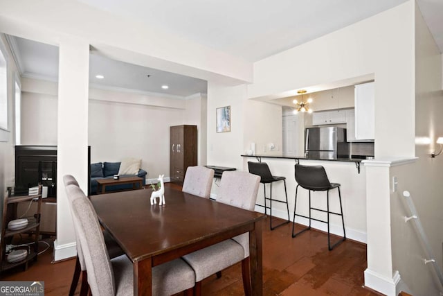 dining space featuring ornamental molding, dark hardwood / wood-style flooring, and a notable chandelier