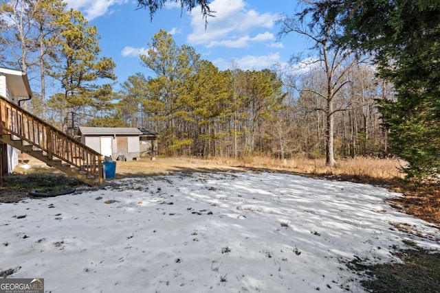 yard layered in snow featuring an outdoor structure