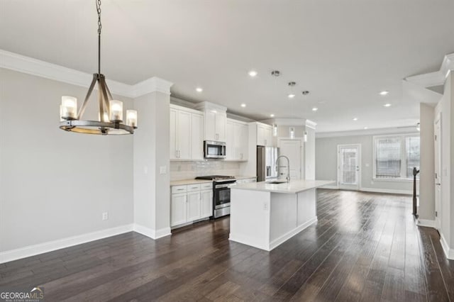 kitchen featuring sink, white cabinetry, a kitchen island with sink, stainless steel appliances, and decorative light fixtures