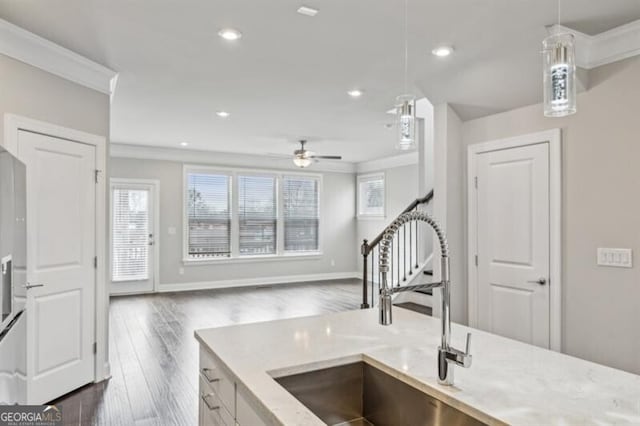 kitchen featuring sink, decorative light fixtures, ornamental molding, dark hardwood / wood-style floors, and ceiling fan