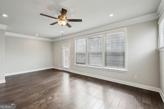 spare room featuring crown molding, a wealth of natural light, dark hardwood / wood-style floors, and ceiling fan