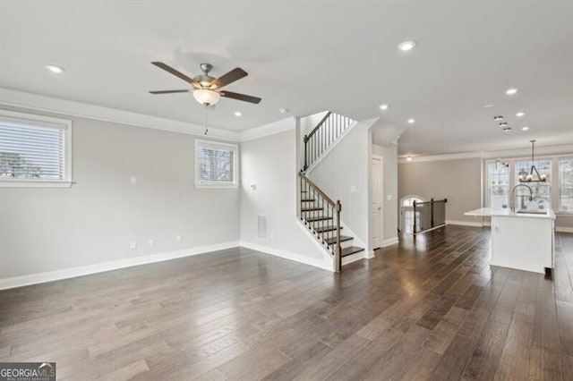 unfurnished living room with crown molding, ceiling fan, and dark hardwood / wood-style flooring