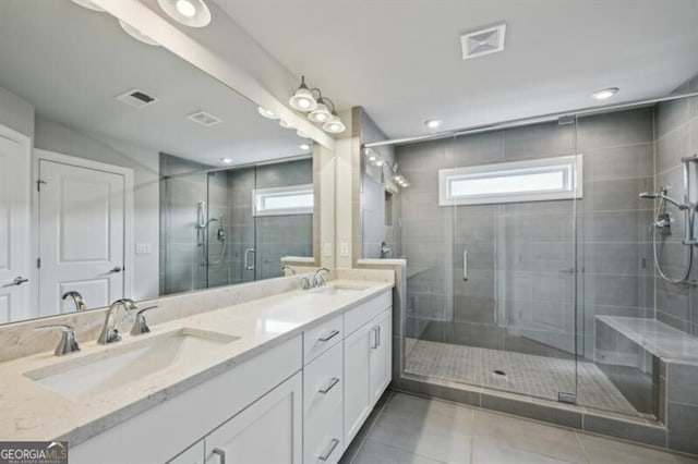 bathroom featuring a shower with door, vanity, and tile patterned flooring